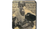 Photo of Lou Howell in Triplets baseball uniform with baseball mitt raised for a catch.