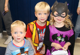 three children in halloween costumes