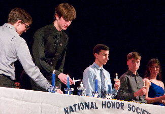 students light candles at NHS induction