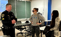 two students speak with police officer at SPARK event