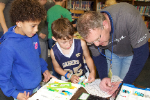 visitor works with two students