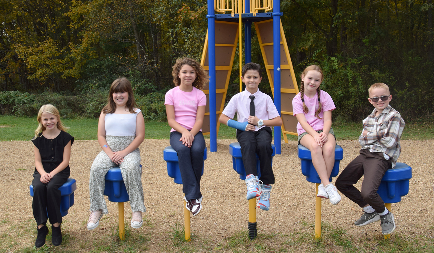 Students from Brookside Elementary sit on stepping spots on the playground.