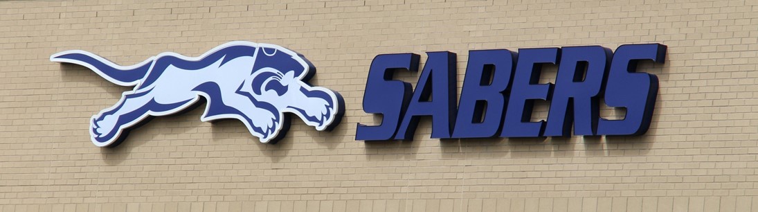 word sabers and figure of pouncing cat on side of building
