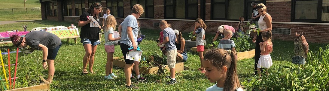 Group of students and parents tending to garden at Brookside Elementary