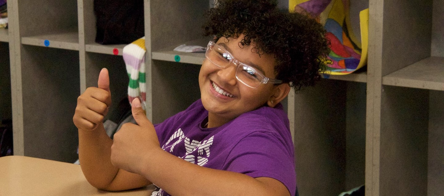 Student smiling and giving thumbs up