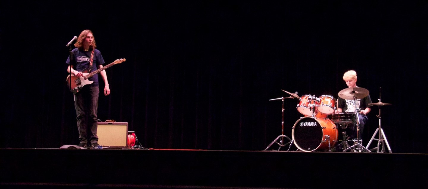 Guitarist and drummer play on stage