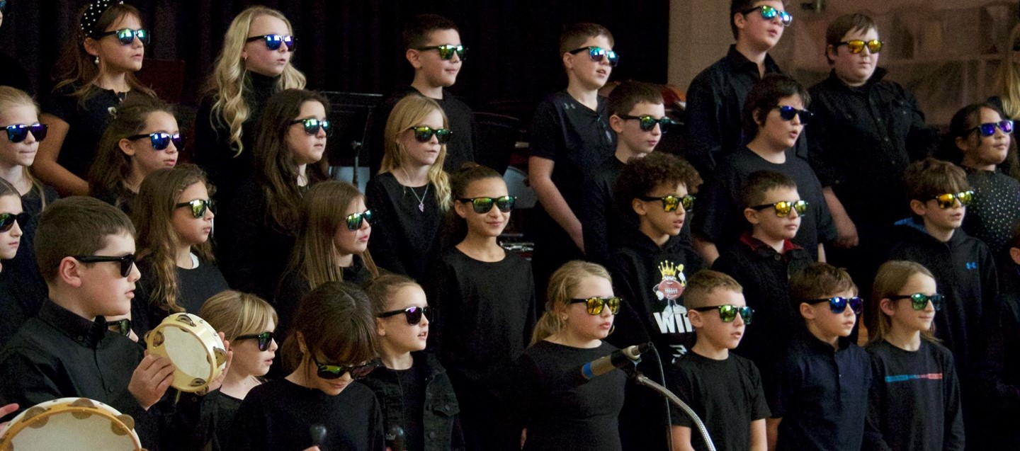 students in sunglasses sing during donnelly winter concert