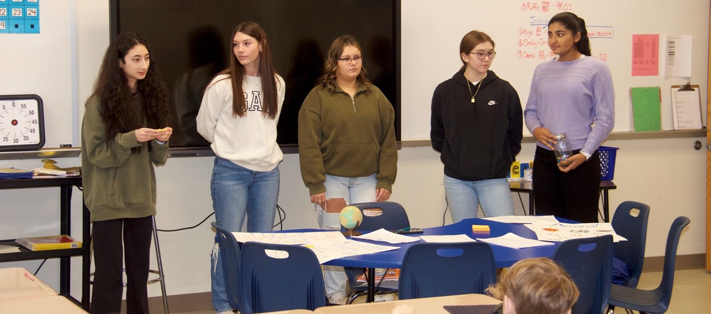 five high school girls give peer leaders presentation in classroom