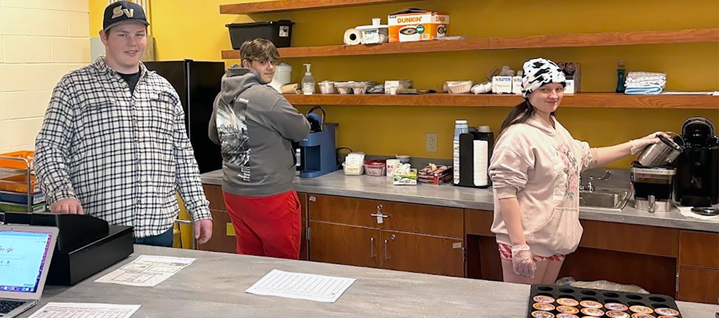 Three Susquehanna Valley High School students manage the morning dunk cafe in the new school library.