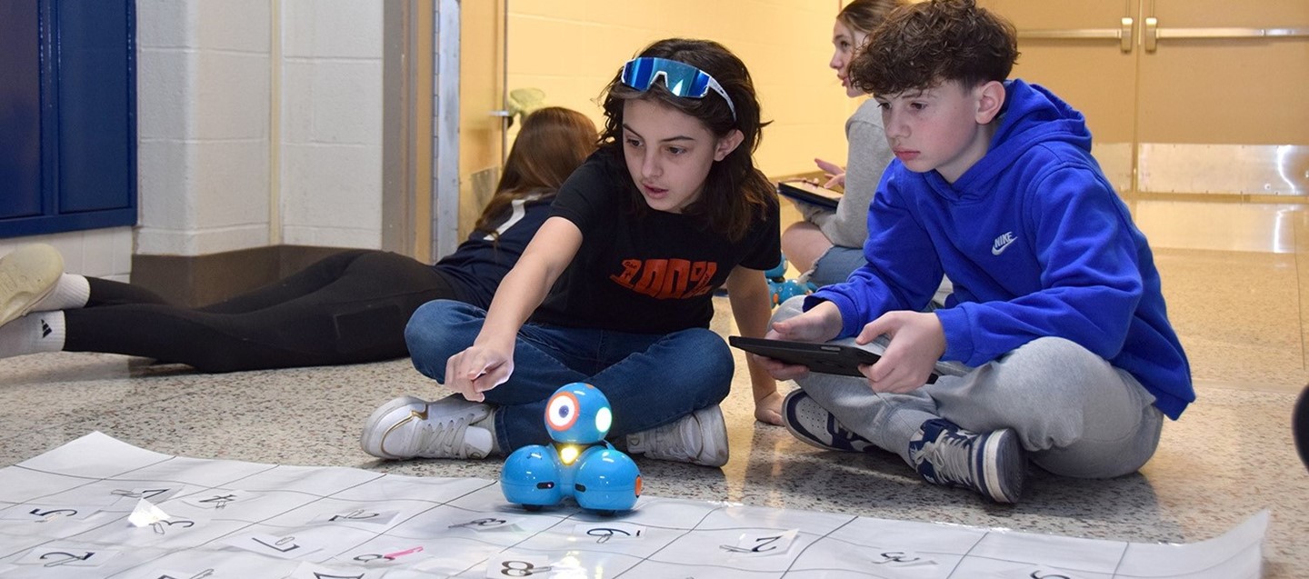 Two Richard Stand Middle School students work together to program a robot to run a course.