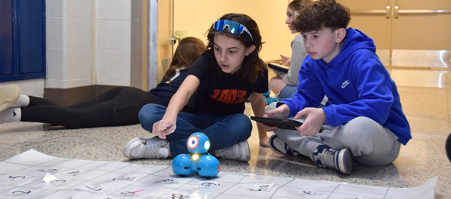 Two Richard Stand Middle School students work together to program a robot to run a course.